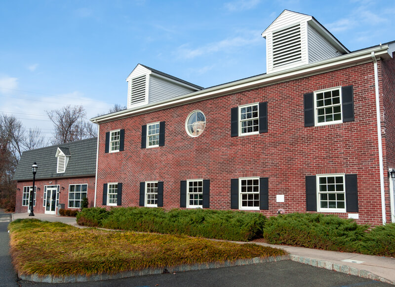 The Schumacher Insurance Agency office, a two-story red brick building at 551 Passaic Avenue